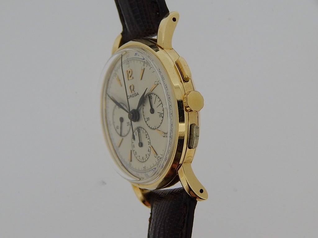 Omega 14k yellow gold chronograph wristwatch with silvered dial, manual-wind movement, acrylic crystal, 34mm diameter. Silvered dial with black hands. Six months full warranty.