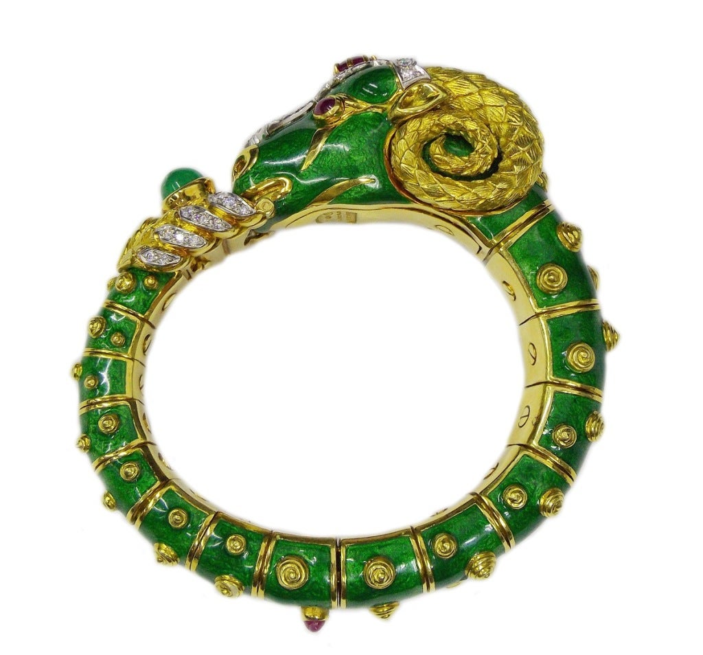 David Webb CAPRICORN RAM Diamond Ruby Emerald Enamel Gold Bangle Bracelet.

The articulated hinged bangle designed as a green enamel ram with sculpted 18k gold spiraled horns and spots, bezel-set with cabochon ruby eyes and forehead, his face