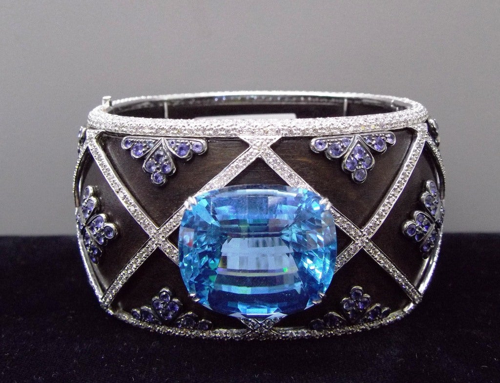 LAURA MUNDER 18K White Gold Superb Blue Topaz Diamond Sapphire Carved Wood Bangle Bracelet. 
Approximately 50ct Faceted blue topaz (1