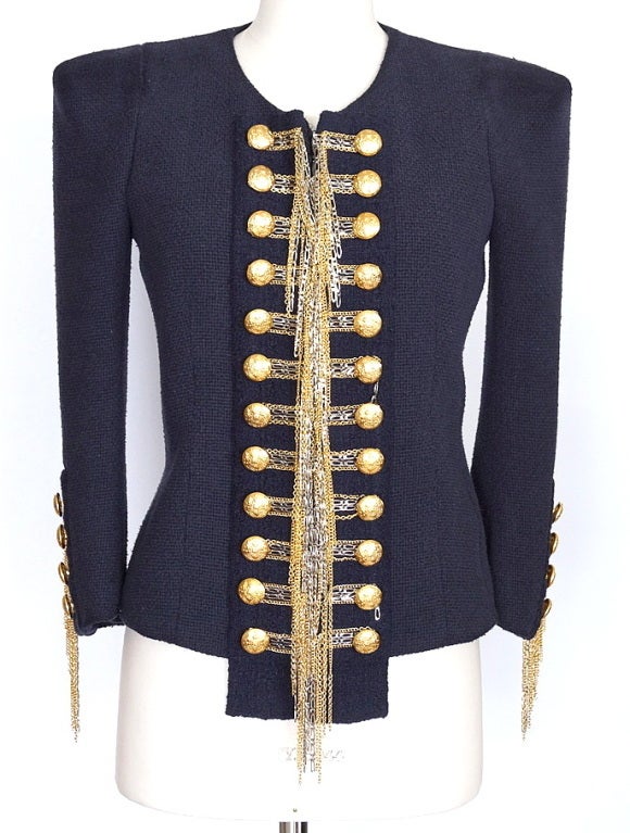 BALMAIN Blue Chain-trimmed Bouclé Jacket.
Navy silk-blend bouclé jacket with gold and silver hanging chain detail through front and cuffs.
Round neck, structured shoulders and 3/4 sleeves.
Decorative gold-crested button fastening detail through