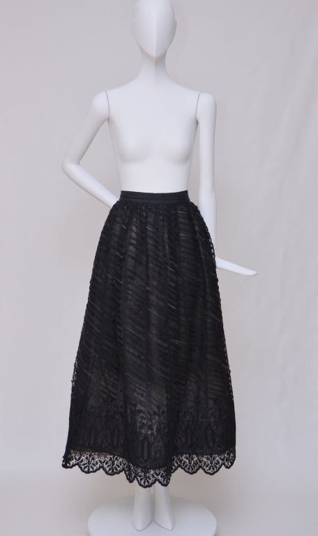 Oscar De La Renta evening black long skirt with beaded accents throughout and side zip closure.Top fabric is mesh with beaded detail and ribbon.Skirt has underskirt with thick bottom that keep the shape and is giving it puff detail.Nude fabric