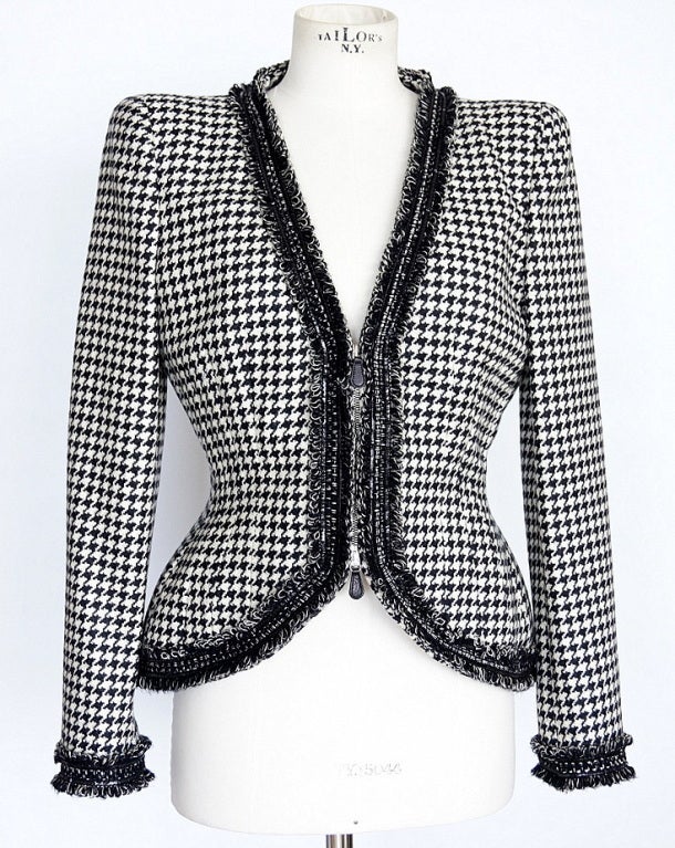Dramatic black and white houndstooth V neck shaped Collectors 2009 jacket.
Subtle padding at the hip and bold shoulder pads to accentuate the waist.
Edged in looped fringe with thin patent leather 'strips'.
Front zipper with leather