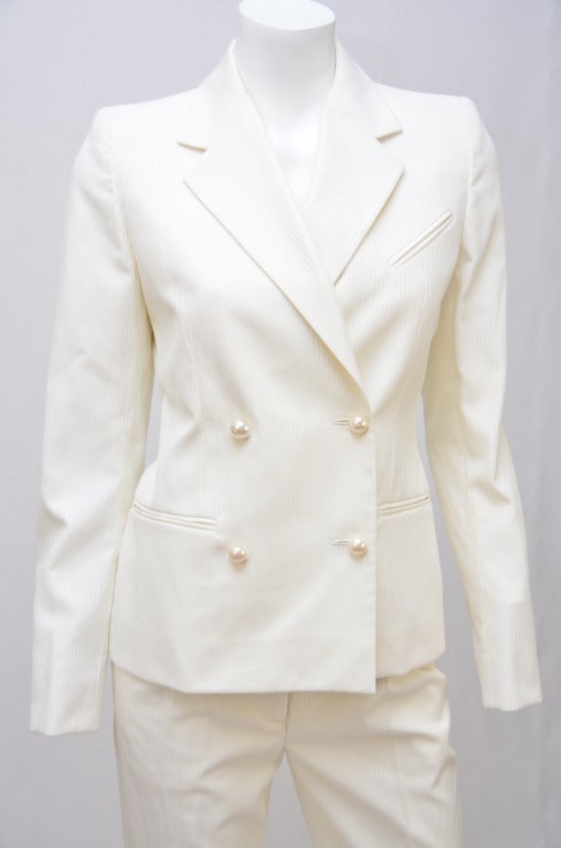 Beautiful Chanel off white  color pant/jacket  suit with pearl buttons on the front and sleeves. Size 38 Fr. Excellent preowned condition. Pants have pockets in the front and back.
Fabric contents: 58% polyamid nylon, 42% cotton.
Made in Italy.