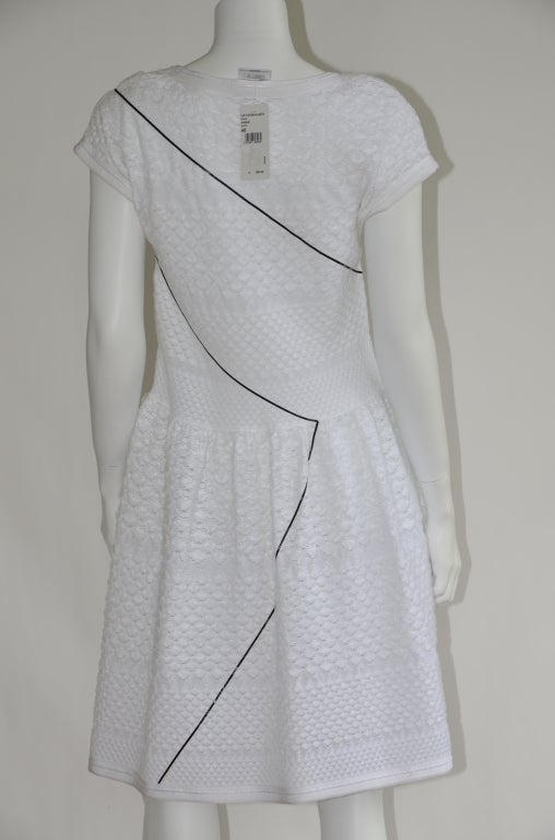 chanel  2012 collection knit dress.
white color  with black line across the dress.
beautiful  and elegant dress you can wear day or night time out.
slip over head with zip side closure.fabric have a stretch to it.
flared skirt hem.form fitting