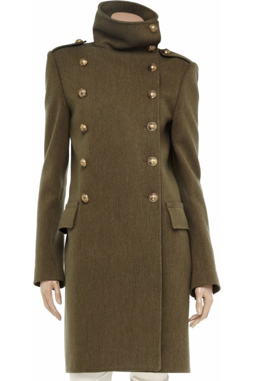 Balmain military coat: army-green mid-weight wool, wide collar, buttoned epaulets, long sleeves, buttoned cuffs, flap pockets, internal welt pockets, back half belt, back vent, fully lined. Embossed button fastenings at double-breasted front. 100%