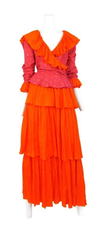Silk 2pc. ensemble in vibrant orange & pink print. Classic YSL ruffle detail at neckline. <br />
Wrap blouse with long sleeves and the maxi skirt is finely pleated silk.