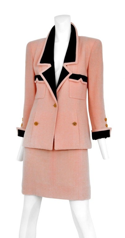 Chanel pink boucle skirt suit with black contrasting trim and gold CC buttons. Elongated waist-line and sharp tailored shoulder. <br />
Jacket: 40