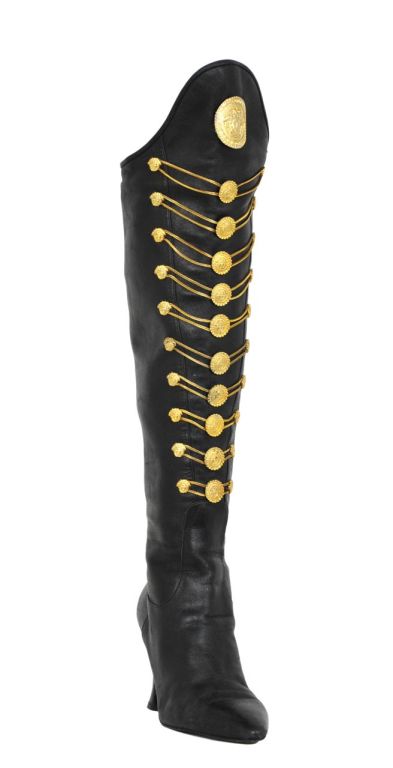 Black soft leather military boots adorned with 30 gold  medusa buttons, a large medusa medallion and gold chain laces.