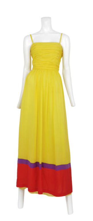 Vibrant yellow chiffon gown with red and purple coloring blocking detail. A horizontal gathering detail at bodice with cut out and tie detailing at the back.