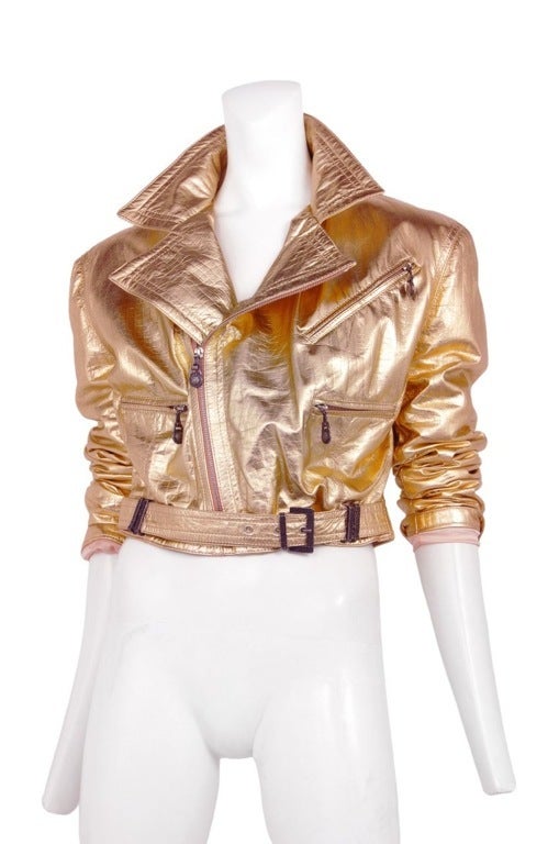 Metallic rose gold leather crop jacket with zipper detail and attached belt at waist.
