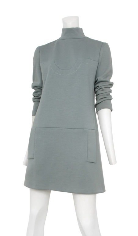 Seafoam teal mini dress with mock turtle-neck, front slit pockets at each side and geometric seam detail across the bodice.