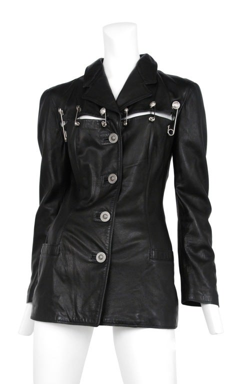 Soft black leather classic cut blazer with slash detail. The slash details are fastened with Medusa adorned silver safety pens. Button front closure.