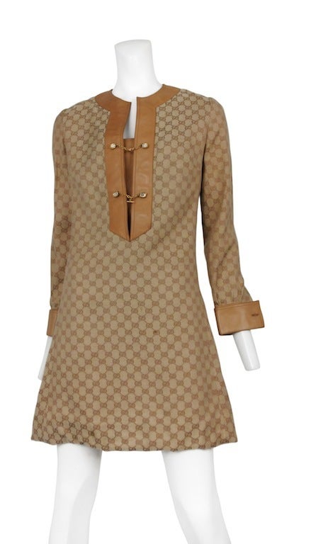 1970's Gucci Monogramed silk blend tunic dress with tan leather trim. Classic gilt horse hoof hardware buttons and cuff links.