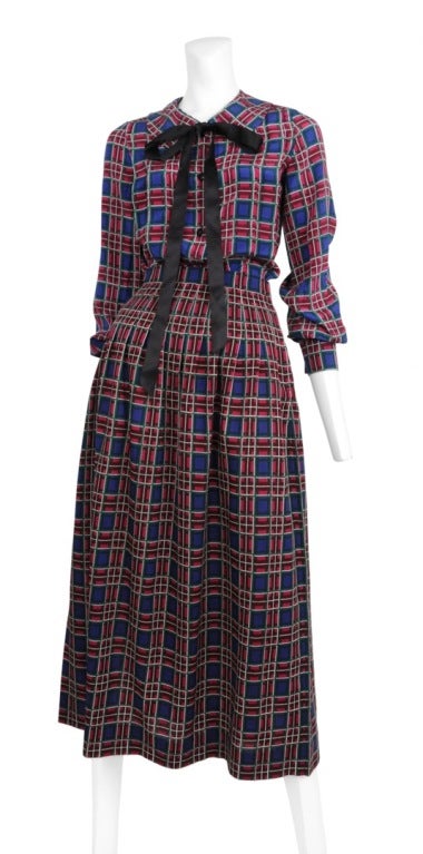 Chanel deep plaid two piece ensemble. Lovely royal blue and magenta print silk blouse with black satin bow. Skirt is a wool print plaid with large pleats to the ankle.