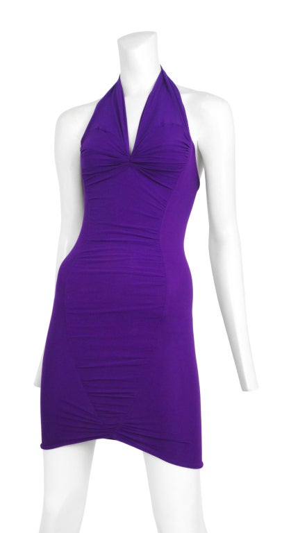 Dark purple cocktail dress done in Iconic Sant Angelo mesh overlay with ruched panel detail. Plunging halter neckline and daring open back.