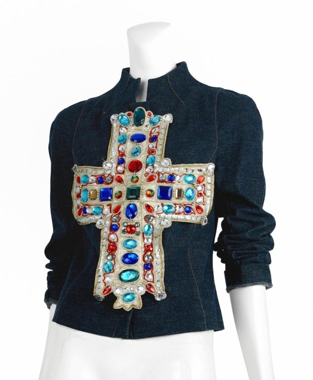 Iconic Christian Lacroix stretch denim jacket with jewel encrusted medieval cross. Short nehru collar with snap and zip front closure.