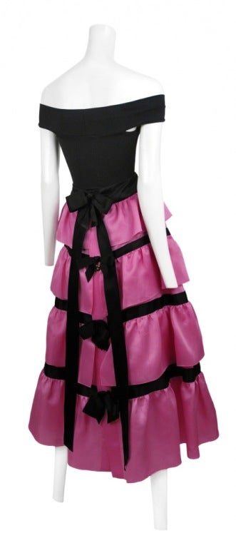 Bright Pink Organza ruffle tiered ball gown skirt with black satin bow trim. Set includes Off Shoulder black lycra bodysuit.