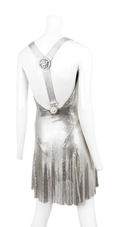 Gianni Versace Atelier silver metal chain mail cocktail dress. Drape front bust line with slight swing skirt above the knee. Medusa emblem logo suspenders are detachable.