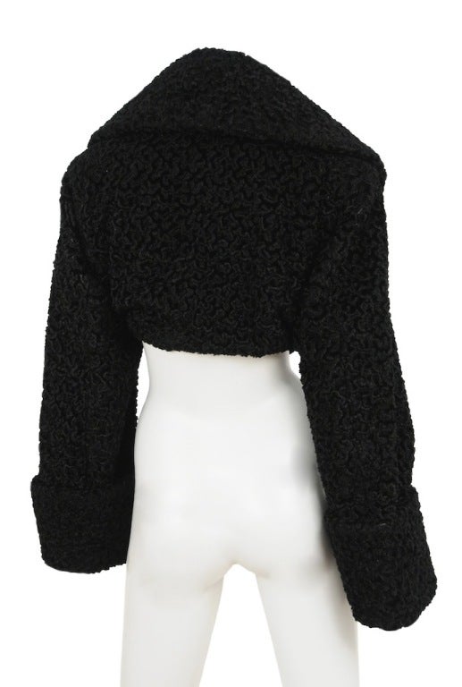 Alaia black faux fur cropped jacket with wide lapel and oversized sleeves and cuffs.  Closure is a fabric loop toggle.