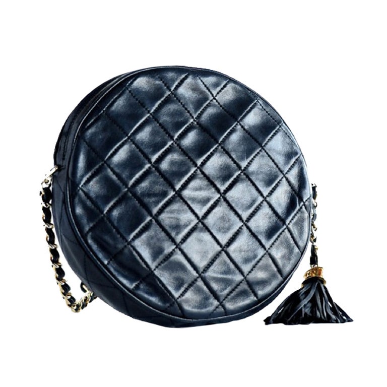 Chanel blacks mini round bag, this is a must for any collection!!<br />
Done in Chanel's classic black quilted lambskin.  It also had a leather and chain strap with a tassel zipper pull. So FUN!