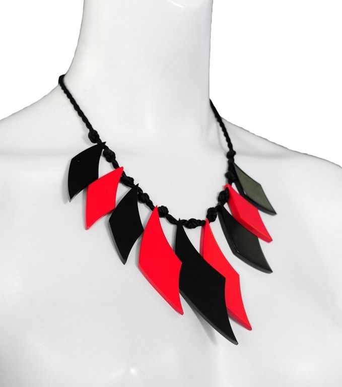 Yves Saint Laurent stunning runway piece, rare!<br />
It is red and black african inspired geometric shape charms that dangle from a black thin silk rope. There are two red tassels that add interest at the tie back.