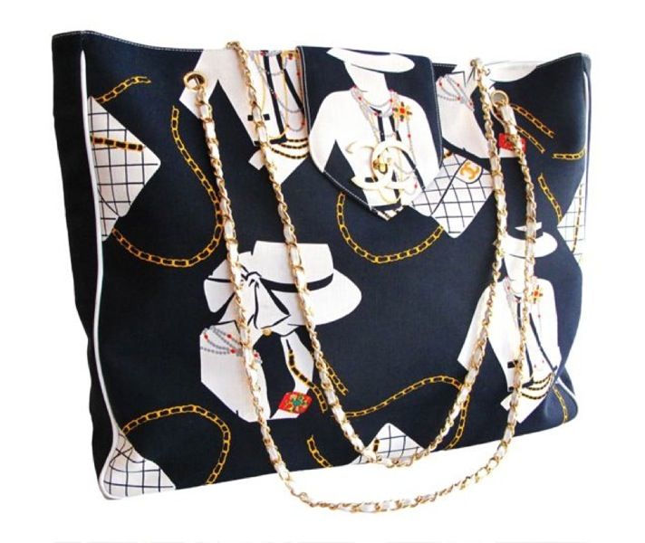 Navy canvas oversized tote with quilted classic 2.55 and Coco silhouette print in white. Leather and gold chain double detachable strap and gold CC twist latch closure.