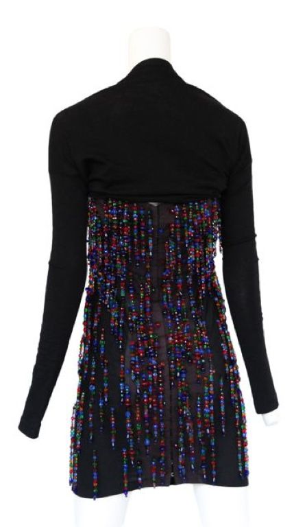 Black jersey wiggle dress with multi color beaded fringe with a scoop v-neck and built in shrug. c. 1990's