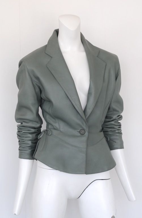 Putty gray leather sports jacket with cinched waist line, classic Alaia seam detail and ties at sides.