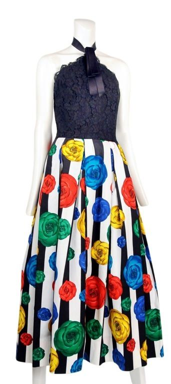 Vibrant floral and wide striped printed cocktail dress with halter lace bodice and satin ribbon at neckline. The strip is a classic Chanel black and white with the floral print saturated  in blue, red, yellow and green.