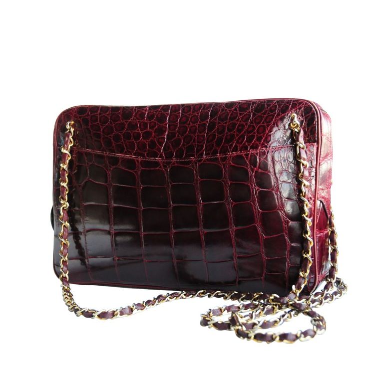 Burgundy crocodile handbag with double leather and chain straps and top zip closure. <br />
Front slit pocket and leather pipping trim around edges.