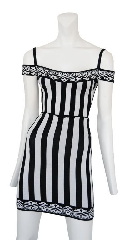 2 pc. stretch viscose mini in graphic black & white strips. Off the shoulder cap sleeves with black thin straps at shoulders. Top is a body suit with snap closure.