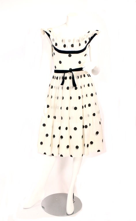 1950's Ceil Champman knockout cocktail dress! Features velvet detail, velvet belt, and boning at the bust. Three layered full skirt. White and black polka dot. Extremely wearable yet a design piece.