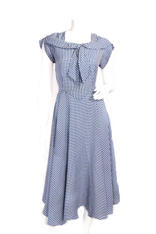 Super chic 1940's blue check dress. Sailor inspired neckline with small shoulder pads. Features tie at the waist, making this dress adjustable. Also has a side zipper. I just adore this fit and style, very wearable!