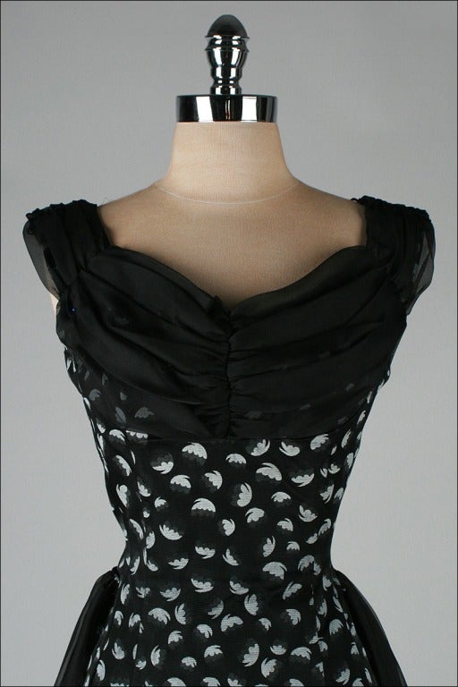 vintage 1950's dress

* black rayon faille
* black chiffon bodice and side sashes
* white petal print
* metal back zipper

condition | excellent

fits like small

length 45