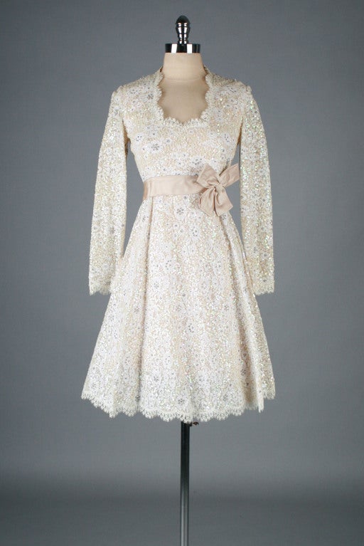 Beautiful 1960's Victoria Royal Ltd dress.  Ivory lace with sequins and beaded detail over nude acetate lining.  Satin waist bow.  Metal back and wrist zippers.  Scallop neckline.  Even more stunning in person.

Excellent condition - just one