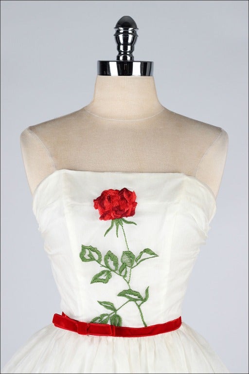 vintage 1950's dress

* ivory organza
* tulle and acetate linings
* red rose on stem embroidery
* velvet ribbon at waist
* strapless bodice with stays
* metal back zipper
* never worn - original tags still attached

condition |