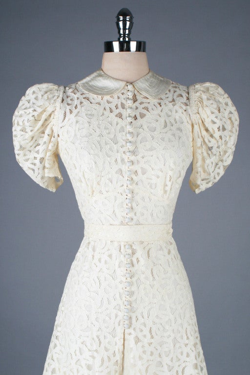 1930's ivory lace Battenburg lace wedding gown.  Puff sleeves, covered button front closure, matching belt and acetate collar and hem.  Comes with original matching slip.  Unbelievable condition for it's age - just a few very small marks - the most