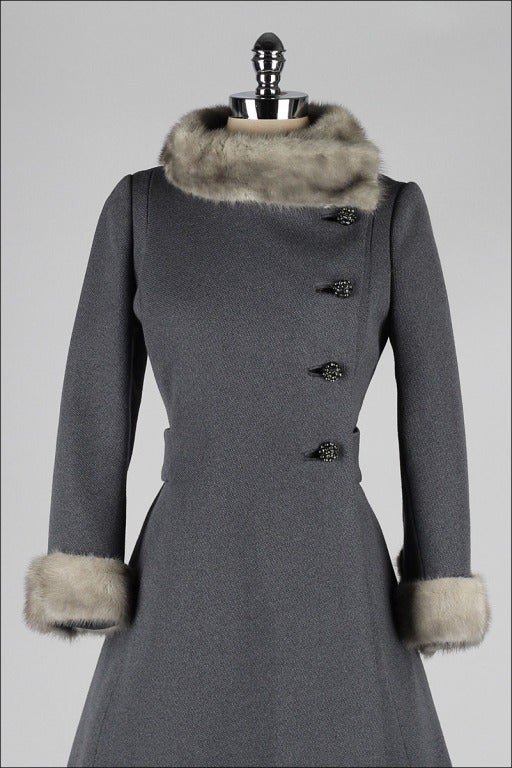 vintage 1960's coat

* gray wool
* silver mink fur trim
* satin lining
* rhinestone buttons
* besom pockets

condition | excellent - few stones missing from buttons

fits like xs/s

length 37
