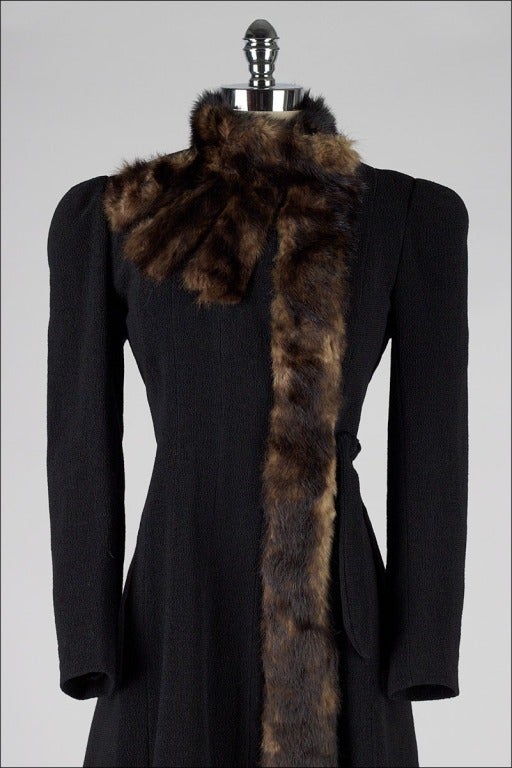 vintage 1940's coat

* black wool 
* mink trim with fanned detail at shoulder
* satin lining
* left waist tie

condition | excellent

fits like small

length 41