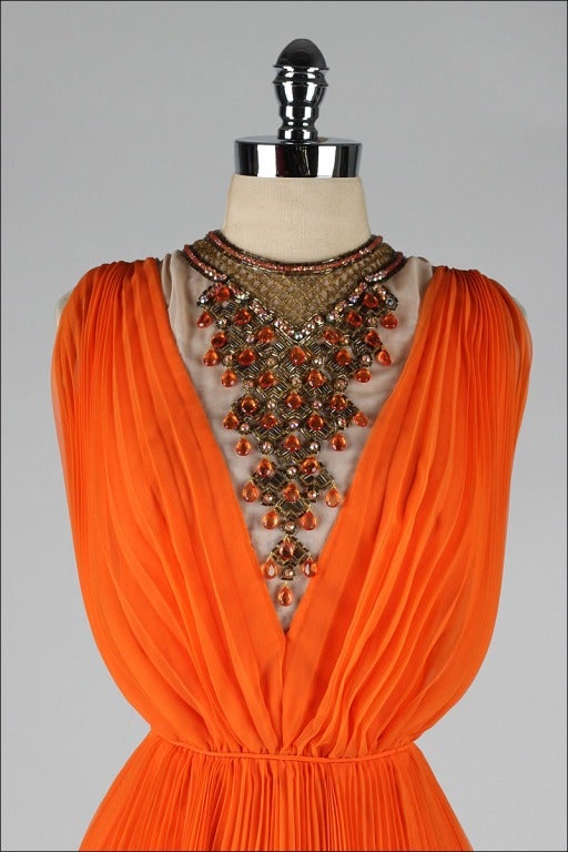 vintage 1960's dress

* tangerine orange chiffon
* illusion neckline
* jeweled bib
* acetate lining
* back zipper
* by Jack Bryan

condition | excellent

fits like large

length 40