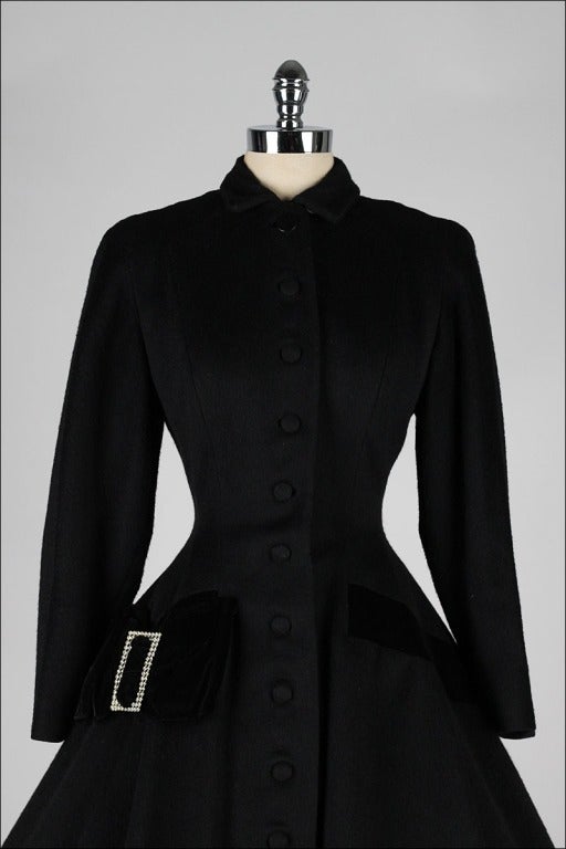 vintage 1950's coat

* black wool
* silk velvet trim
* rhinestone accented buckle
* front button closure
* satin lining
* besom pockets

condition | excellent

fits like small

length 45