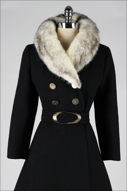 vintage 1960's coat

* black wool
* cross mink fur collar
* hammered steel buttons and belt buckle
* detachable belt
* acetate lining
* besom pockets
* labeled Penn Traffic Co

condition | excellent - button under collar has been replaced