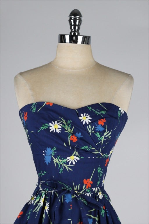 vintage 1950's dress

* blue floral print cotton
* strapless bodice with side stays
* full skirt
* tie belt
* metal back zipper
* by Jeannette Alexander

condition | excellent - bodice has been altered at each side of zipper.  please see
