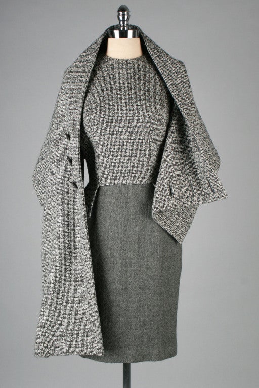 Rare and gorgeous 1950's Mr. Blackwell dress and cape.  Both pieces are made of black, white and gray tweed wool.  Dress is lined in silk crepe and has a back metal zipper.  Amazing asymmetrical cape buttons in front.  

Excellent