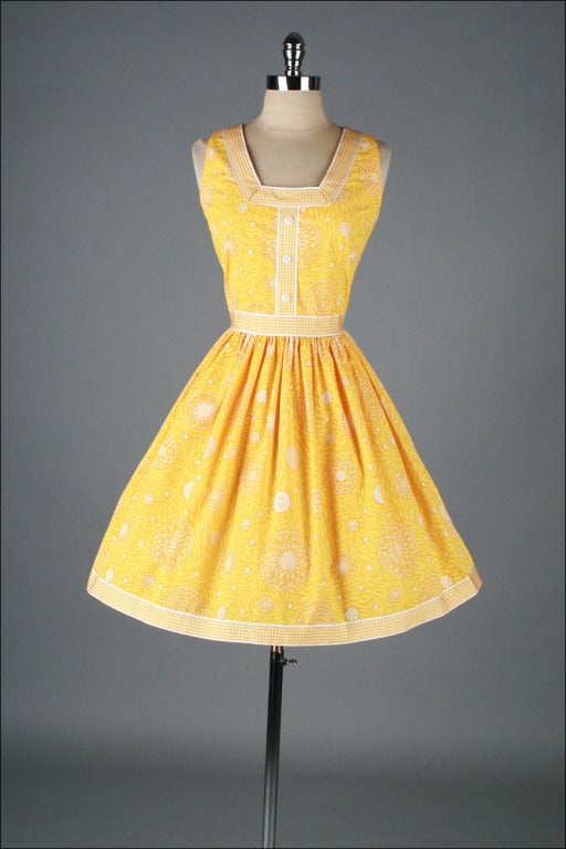 vintage 1960's dress

* yellow polished cotton/poly
* floral print
* gingham and button trim
* metal back zipper
* by Lilly Pulitzer

condition | excellent

fits like m/l

length 38