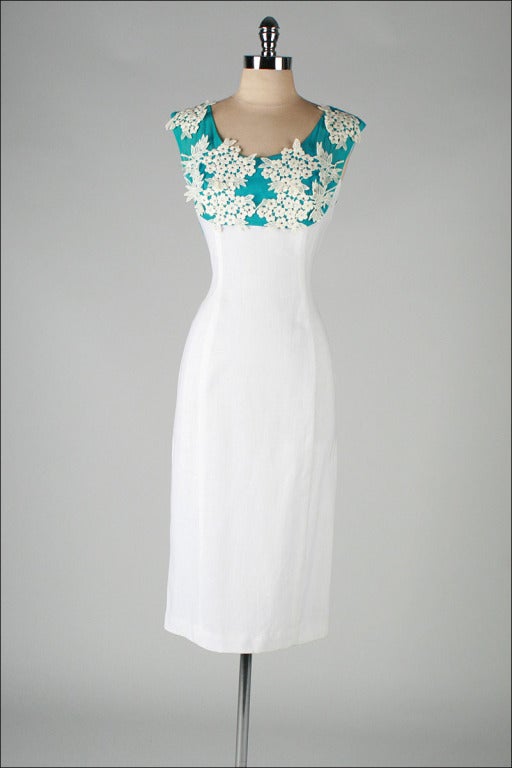 vintage 1950's dress

* white linen
* turquoise chiffon
* white macrame floral lace
* prong set rhinestones
* flower corsage at back waist
* metal back zipper

condition | excellent - one tiny spot at right hip and some discoloration at the