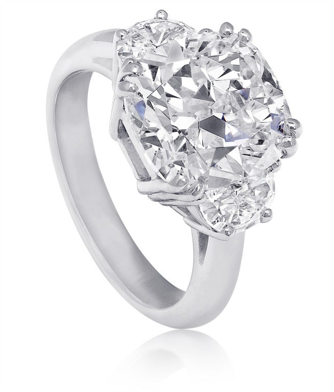 Schöner handgefertigter Verlobungsring aus Platin mit drei Steinen.  In der Mitte befindet sich ein 4::28 Karat großer Diamant im Kissenschliff:: Farbe H.  Flankiert von zwei Trapezen:: präsentiert sich der Ring als sehr großer Diamantring.