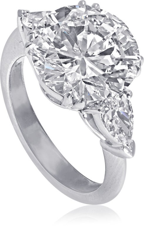 Three stone engagement ring, 5.02 carat Round-cut F color diamond GIA certified SI1 clarity, 0.49 carat Pear-cut diamonds. Set in a handcrafted platinum ring.