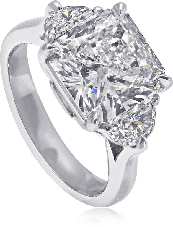 Beautifully handcrafted platinum ring.  In the center is a stunning 3.07 carat Radiant-cut, G color diamond, GIA certified SI1 clarity.  Flanked by two half moon diamonds .64 carat.