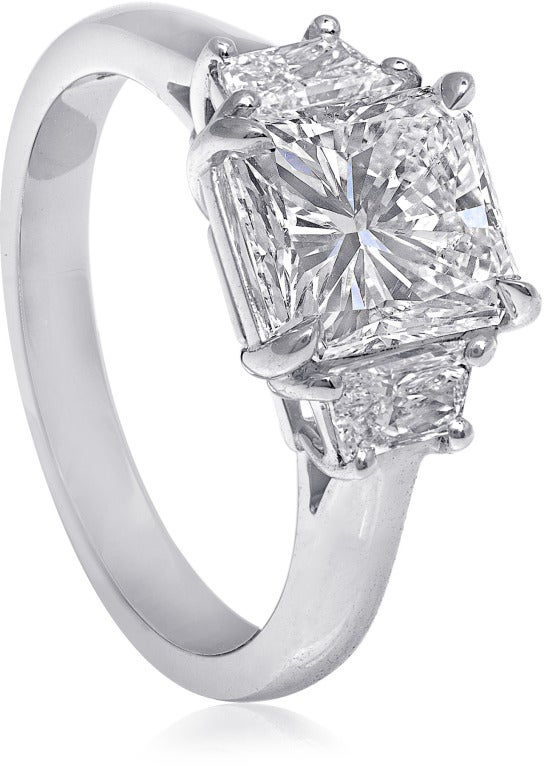 3-stone engagement ring, 2.08 carat Radiant-cut F color diamond GIA certified SI2 clarity, .49 carat Trapezoid-cut diamonds. Set in platinum.